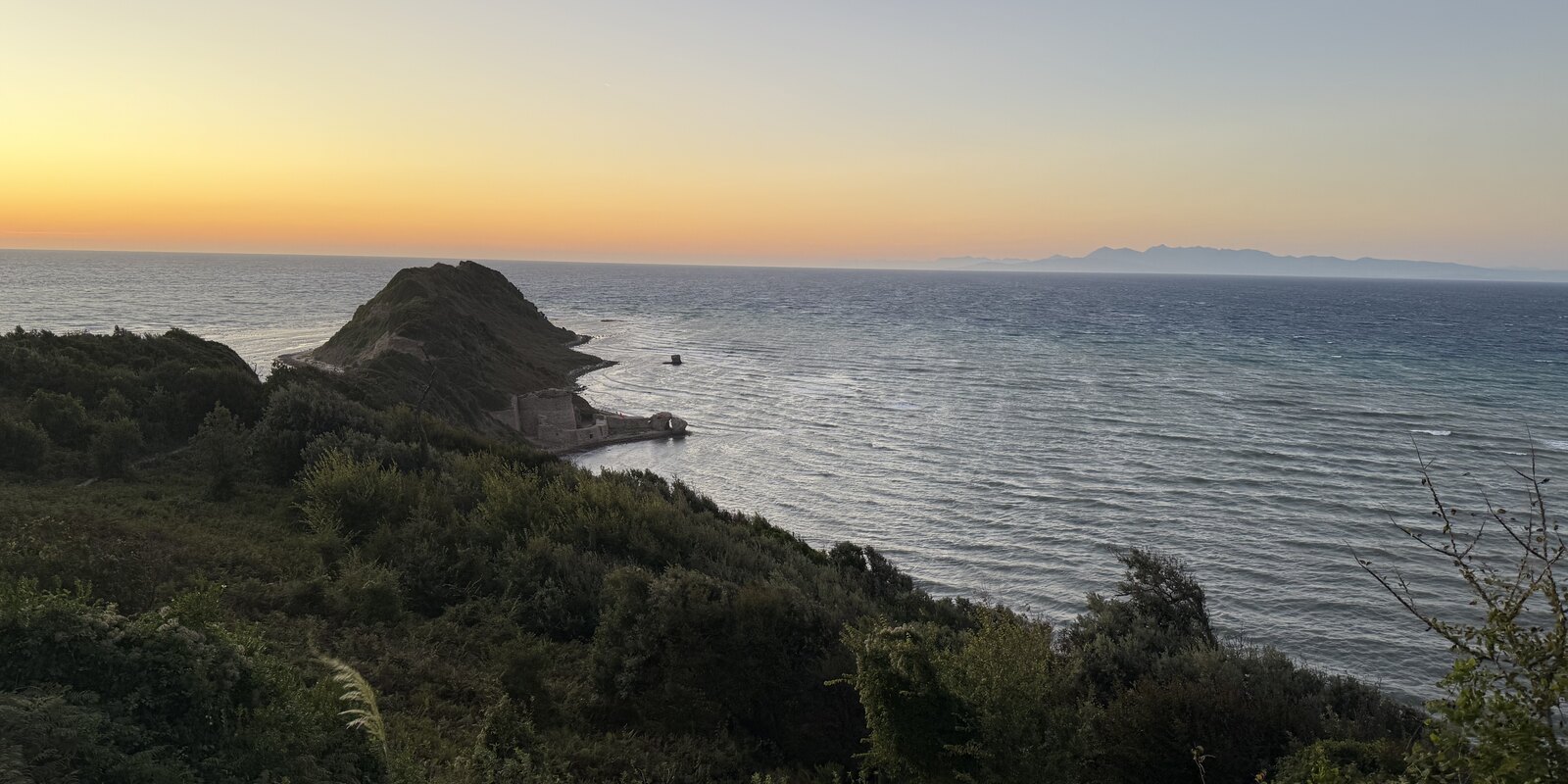 Cape Rodon at sunset, with the headland extending into the sea.